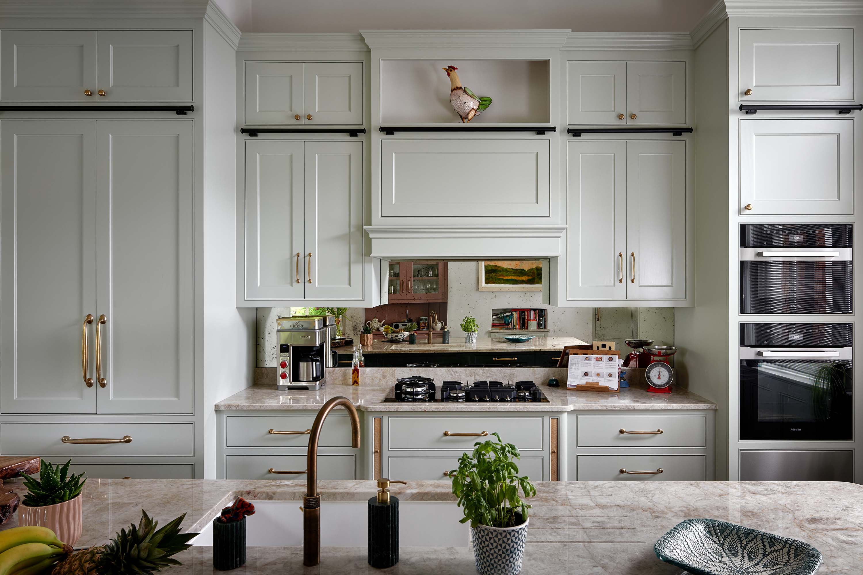 The hob run in a Traditional Shaker Kitchen with a hand silvered antique mirrored splashback and natural quartzite worktop